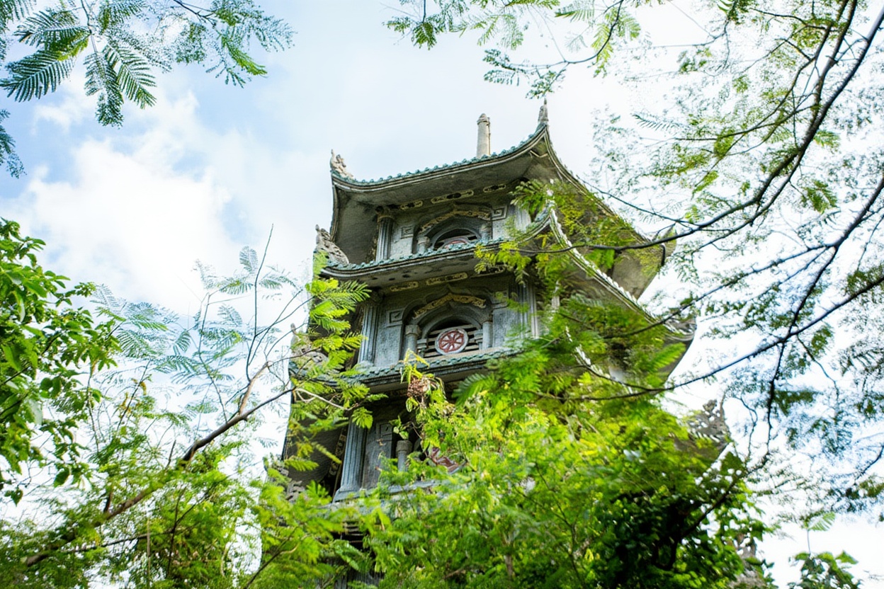 Huyền Không Cave inside the Marble Mountains — natural skylight, pagoda, and bats overhead